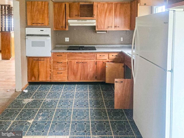 115 Mountain View Rd, Armagh, PA 15920 - kitchen with white appliances, under cabinet range hood, dark flooring, and light countertops