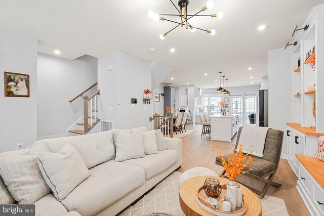 living room with a notable chandelier and light wood-type flooring