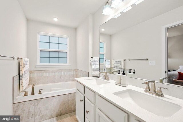 bathroom with radiator heating unit, vanity, and tiled tub