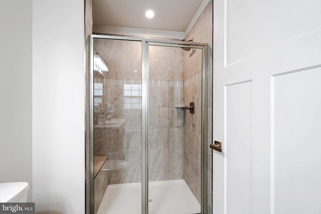 bathroom with an enclosed shower and toilet