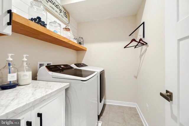 laundry room featuring washing machine and dryer and light tile patterned floors