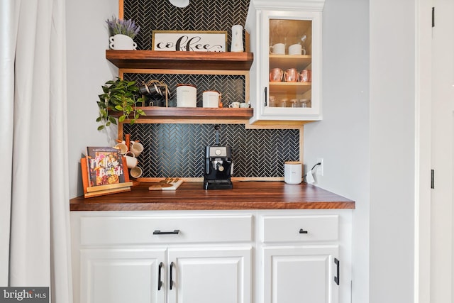 bar featuring white cabinetry and backsplash