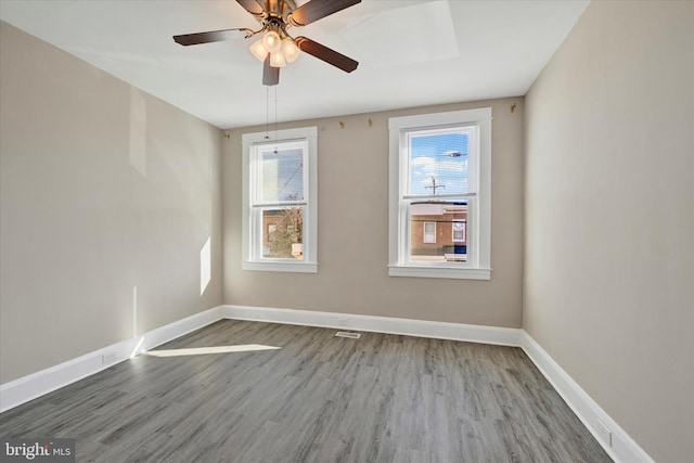 spare room featuring hardwood / wood-style flooring, ceiling fan, and a healthy amount of sunlight