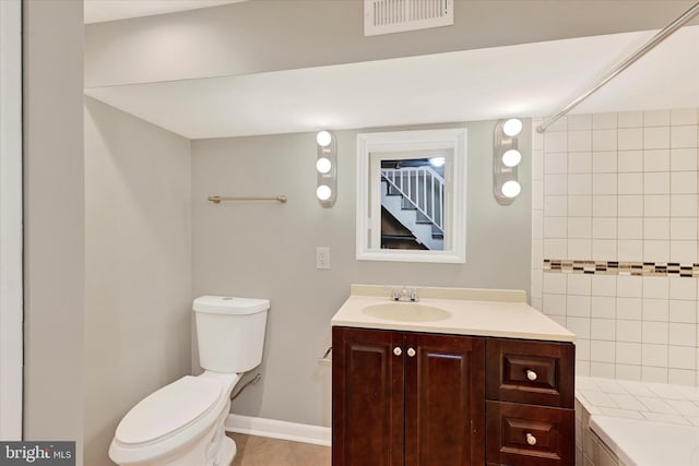 bathroom with tile patterned flooring, vanity, and toilet