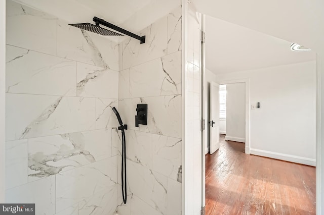 bathroom with hardwood / wood-style flooring and a tile shower