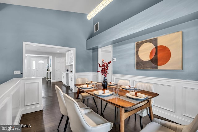 dining area featuring dark hardwood / wood-style floors and a high ceiling