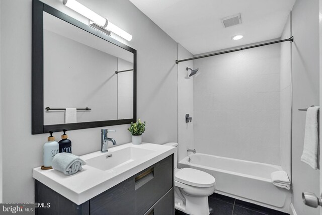 full bathroom featuring tile patterned floors, vanity, tiled shower / bath, and toilet