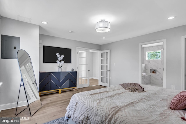 bedroom featuring french doors, connected bathroom, electric panel, and light hardwood / wood-style flooring