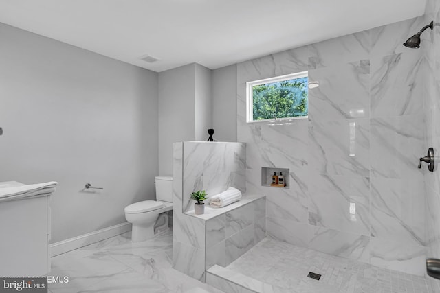 bathroom featuring tiled shower and toilet