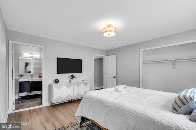 bedroom with light wood-type flooring, ensuite bath, and a closet