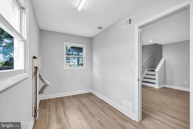 unfurnished room with light wood-type flooring and plenty of natural light