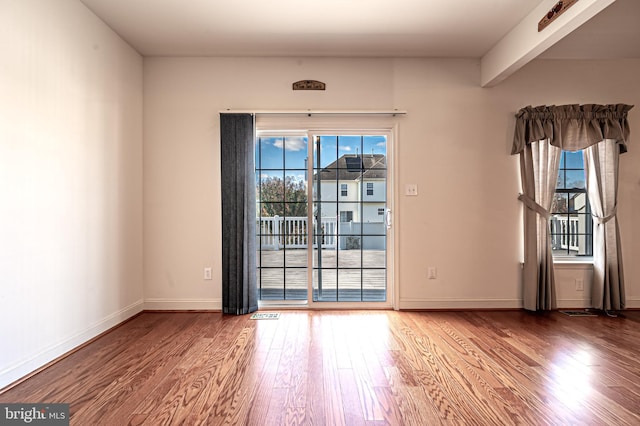 unfurnished room with baseboards and wood finished floors