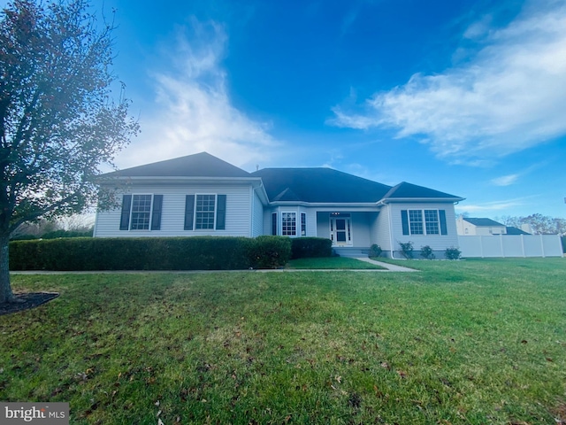 ranch-style home with a front yard and fence