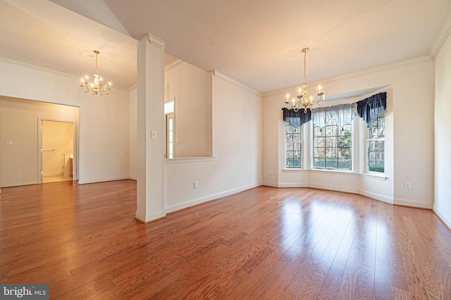 unfurnished room featuring crown molding, baseboards, wood finished floors, and a notable chandelier