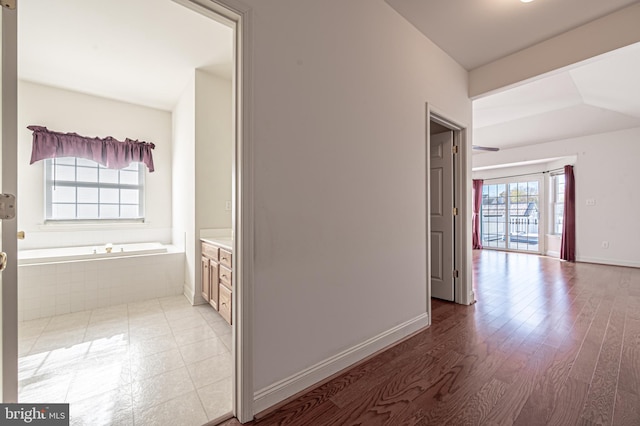 hallway with light wood-style flooring and baseboards