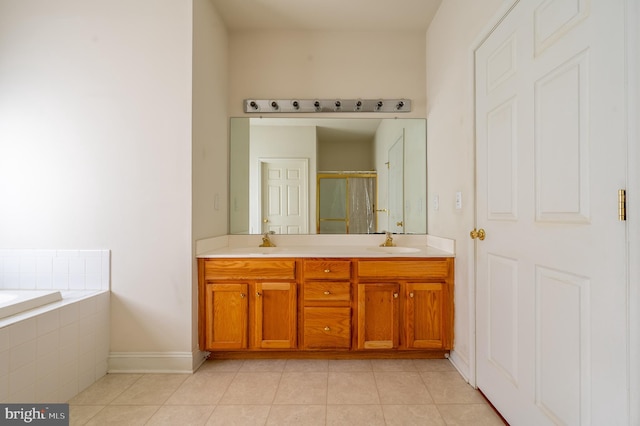 full bathroom with tile patterned flooring, a sink, a shower stall, and double vanity