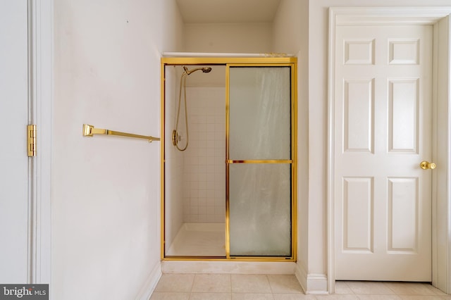 full bathroom with a stall shower, baseboards, and tile patterned floors