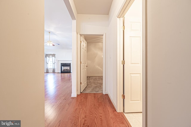 hall featuring light wood finished floors and baseboards