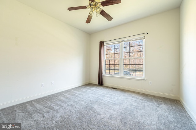 carpeted empty room with a ceiling fan, visible vents, and baseboards