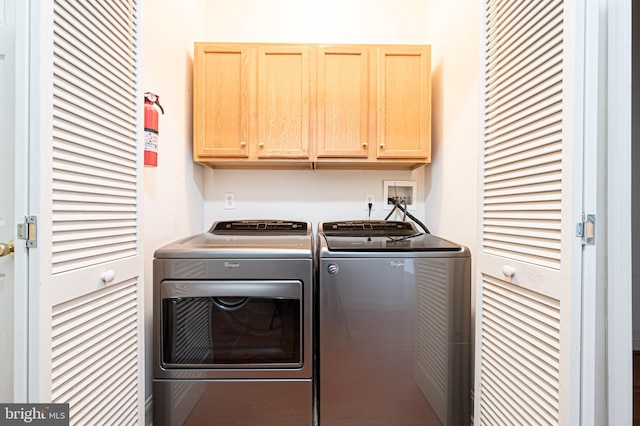 laundry area featuring washing machine and dryer and cabinet space