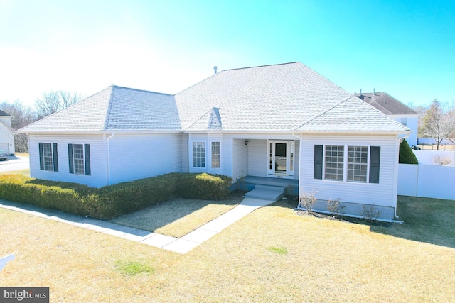 view of front of property featuring roof with shingles, a front yard, and fence