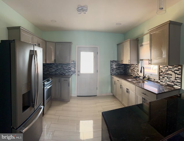 kitchen featuring stainless steel appliances, gray cabinets, tasteful backsplash, and sink