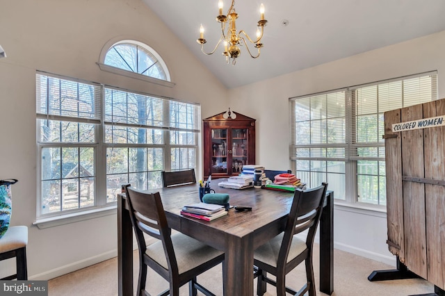 dining area featuring a notable chandelier, light colored carpet, and high vaulted ceiling