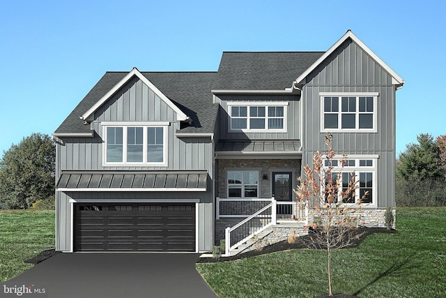 view of front of property with a front yard, a garage, and covered porch