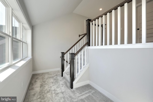 staircase with lofted ceiling and carpet floors