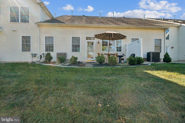 rear view of house with a lawn and central air condition unit