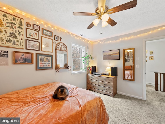 bedroom featuring a ceiling fan, carpet, visible vents, and a textured ceiling