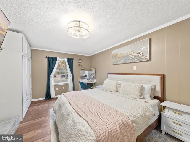 bedroom with a textured ceiling, wood finished floors, and crown molding