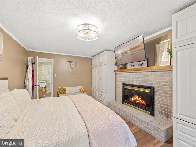 bedroom featuring dark wood-style floors, a brick fireplace, crown molding, and a textured ceiling