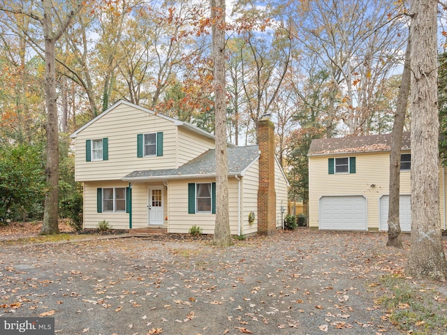 view of front of property featuring a garage, driveway, a chimney, and roof with shingles