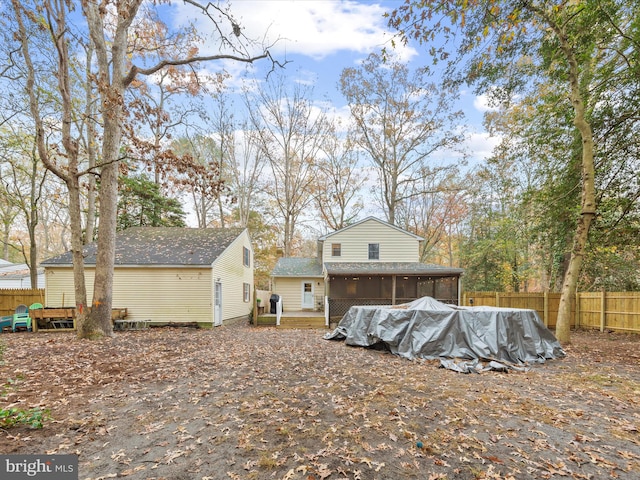 back of house featuring a sunroom, fence, and a wooden deck