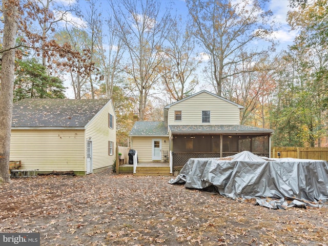 back of house with a wooden deck, a sunroom, and fence