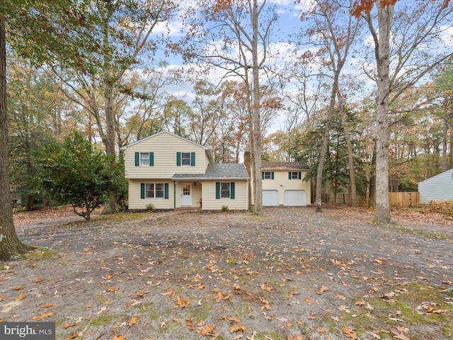 view of front of house with a garage and fence