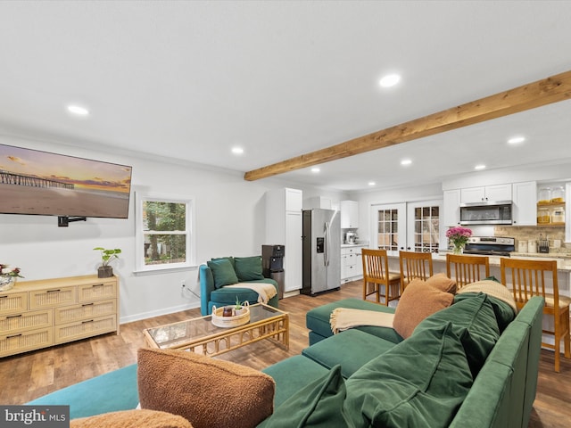 living area featuring light wood-style floors, recessed lighting, french doors, and beamed ceiling