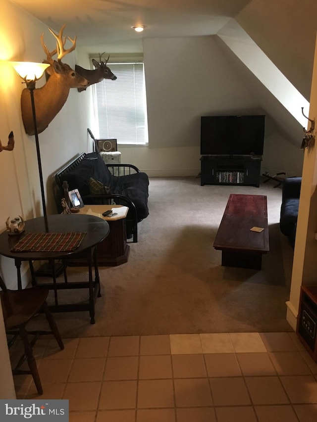 sitting room with carpet flooring and vaulted ceiling with skylight