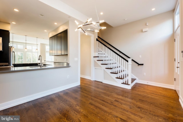 interior space featuring an inviting chandelier, sink, and dark wood-type flooring