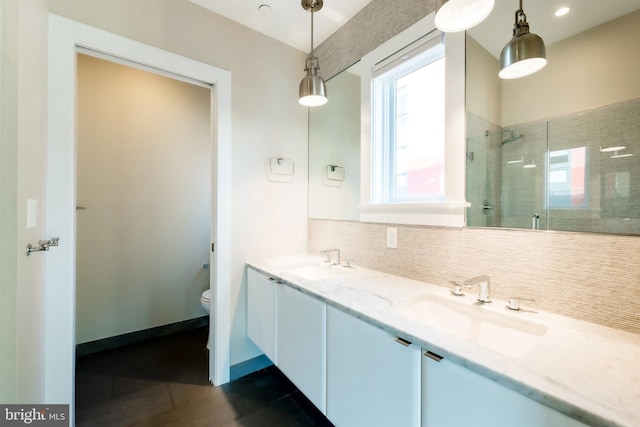 bathroom featuring vanity, tile patterned flooring, decorative backsplash, toilet, and an enclosed shower