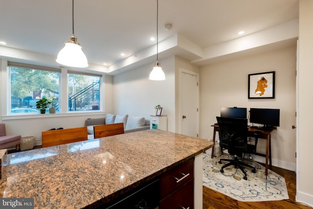 kitchen featuring dark hardwood / wood-style flooring, decorative light fixtures, and light stone counters