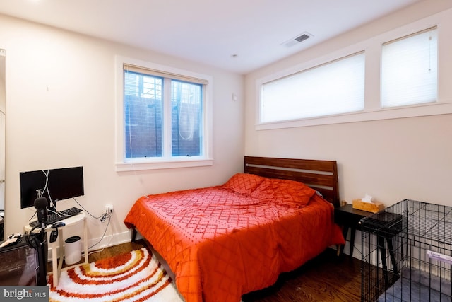 bedroom featuring dark hardwood / wood-style floors and multiple windows