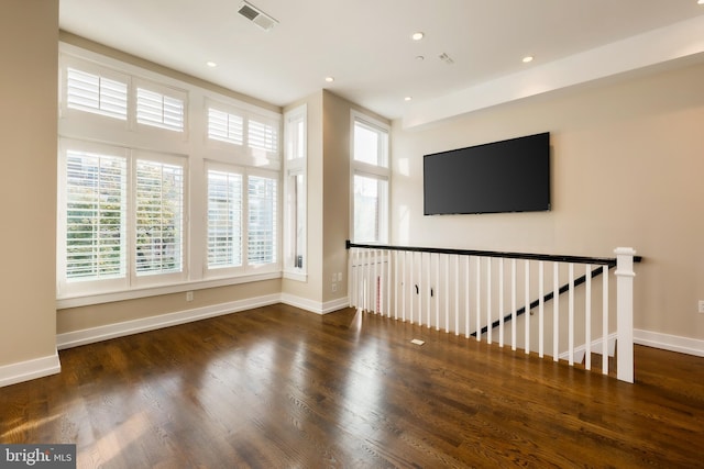 spare room featuring dark hardwood / wood-style flooring and plenty of natural light