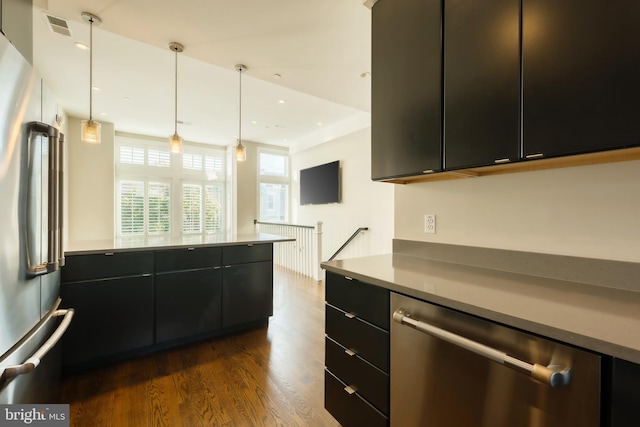 kitchen featuring dark hardwood / wood-style floors, hanging light fixtures, and appliances with stainless steel finishes