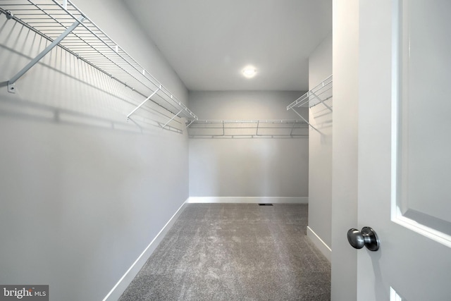 spacious closet with dark carpet