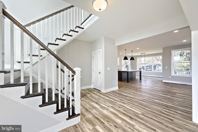 stairway with sink and hardwood / wood-style flooring