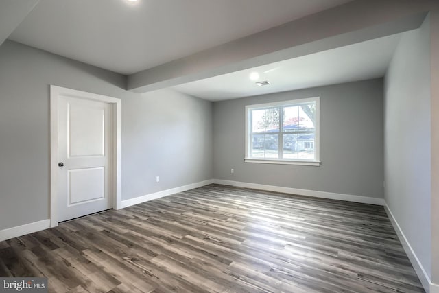 unfurnished room with dark wood-type flooring