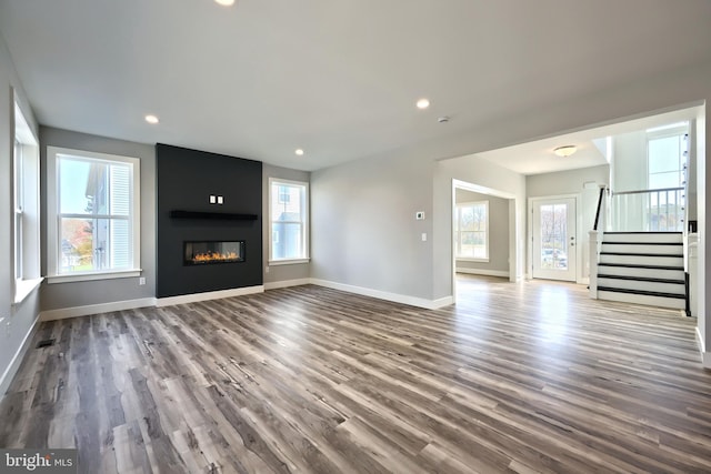 unfurnished living room with a large fireplace and hardwood / wood-style floors