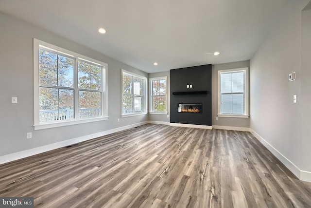 unfurnished living room with a large fireplace and wood-type flooring